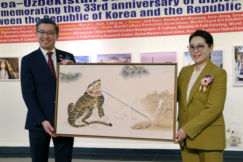 Uzbekistani Ambassador to Korea Alisher Abdusalomov (left) on March 5 poses with Myongji University professor Lee Mi-hyung at a ceremony for the donation of her artworks on the sidelines of the opening ceremony for a cultural exchange exhibition marking the 33rd anniversary of Korea-Uzbekistan ties at Insadong Korea Gallery in Seoul's Jongno-gu District.  