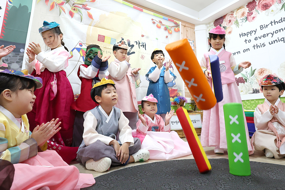 Students at a preschool in Incheon's Bupyeong-gu District on Sept. 12 play the traditional board game yunnori while wearing Hanbok (traditional clothing) two days before the start of the Chuseok (Korean Thanksgiving) holidays.