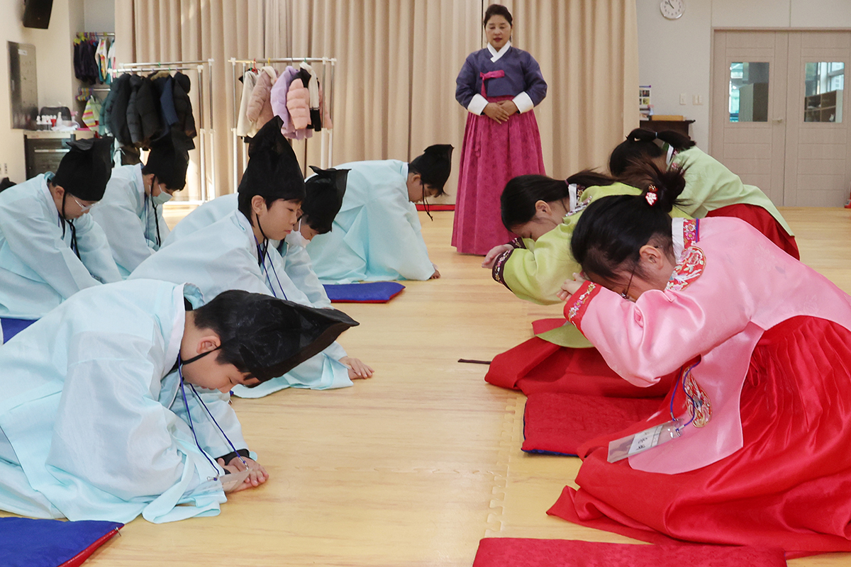 Elementary school students in a traditional cultural experience program over winter vacation on the morning of Jan. 6 learn traditional bowing wearing Hanbok (traditional clothes) at the traditional Confucian academy Annak Seowon of Chungnyeolsa Temple in Busan's Dongnae-gu District. 